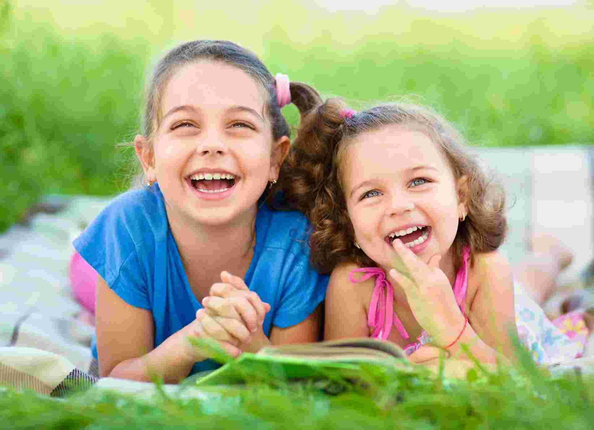 Smiling children playing outdoors after chiropractic care