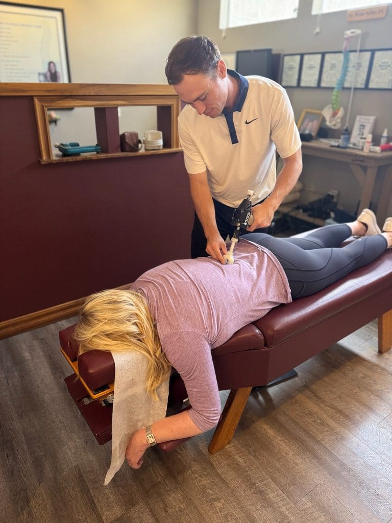 Side angle of chiropractor adjusting woman on chiropractic table
