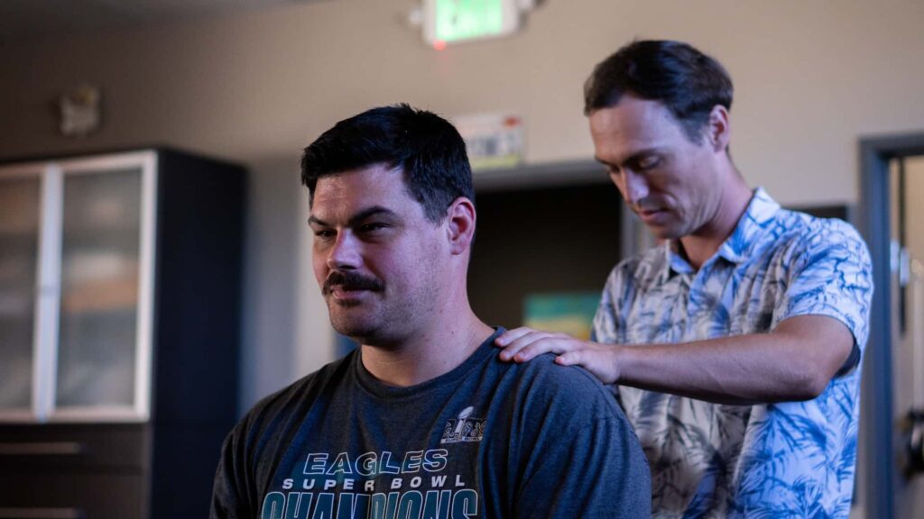 Chiropractor evaluating posture during new patient consultation