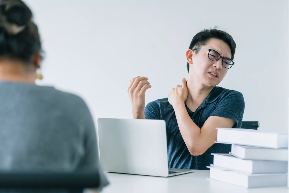 Man suffering neck pain from desk work posture