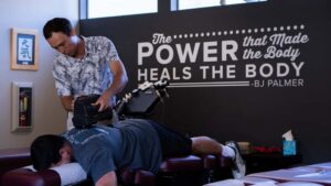 Dr. Riley Miller performing a neck adjustment with a drop table