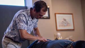 Dr. Riley Miller using the lumbar drop piece on the treatment table