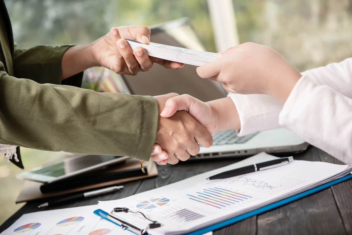 Chiropractor and patient shaking hands while dealing with insurance