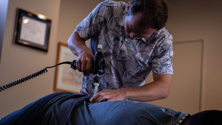 Chiropractor providing back pain relief treatment to patient