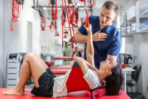 Therapist guiding patient through suspension strap rehabilitation exercise